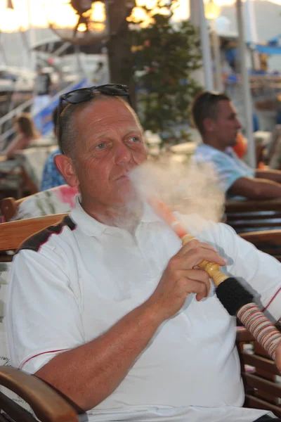 Hombre fumando una pipa de agua de narguile —  Fotos de Stock