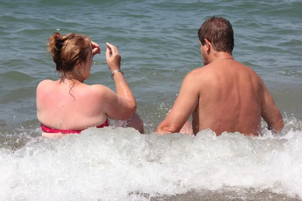 Um casal sentado na praia — Fotografia de Stock