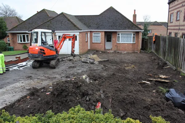 A mini digger excavating a driveway — Stock Photo, Image