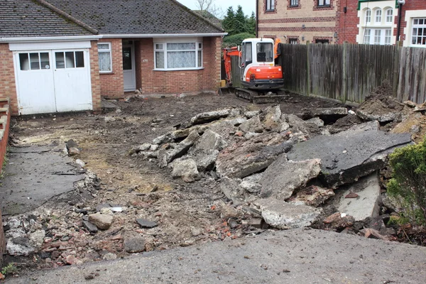 En mini grävare grävning en uppfart — Stockfoto