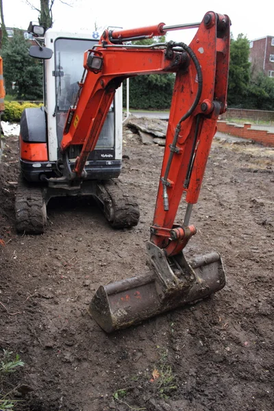 Una mini excavadora excavando un camino de entrada — Foto de Stock