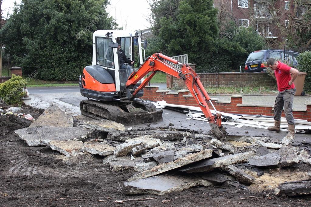 A mini digger excavating a driveway Stock Editorial Photo © 1markim