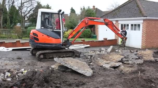 A mini digger excavating a driveway — Stock Video