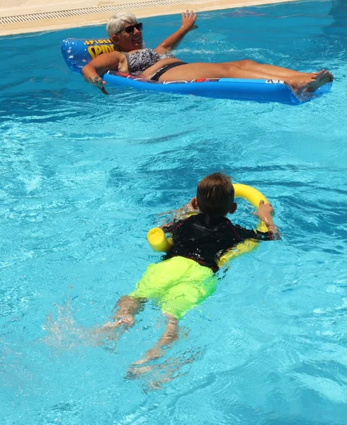 Ein kleiner Junge und eine Dame in einem Schwimmbad — Stockfoto