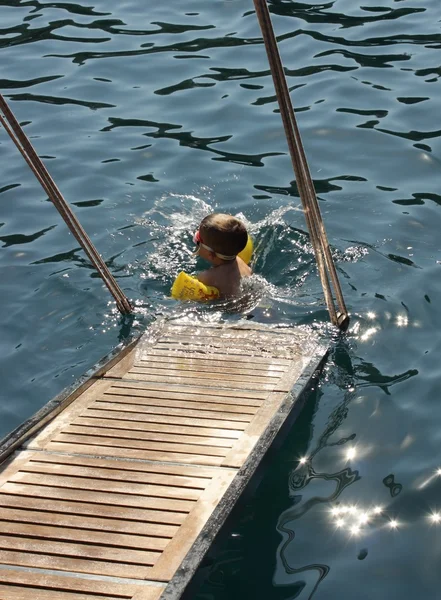 Um menino em uma natação no mar — Fotografia de Stock