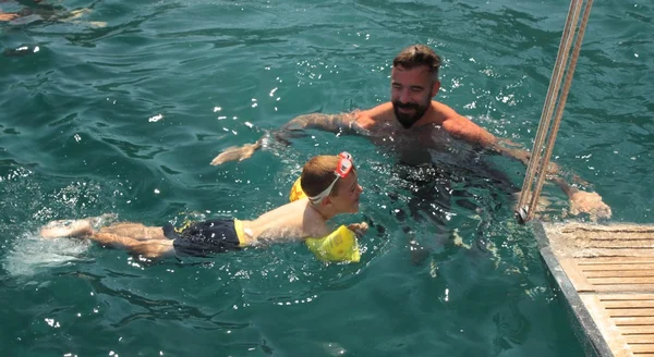 Um pai e um filho nadando no mar — Fotografia de Stock