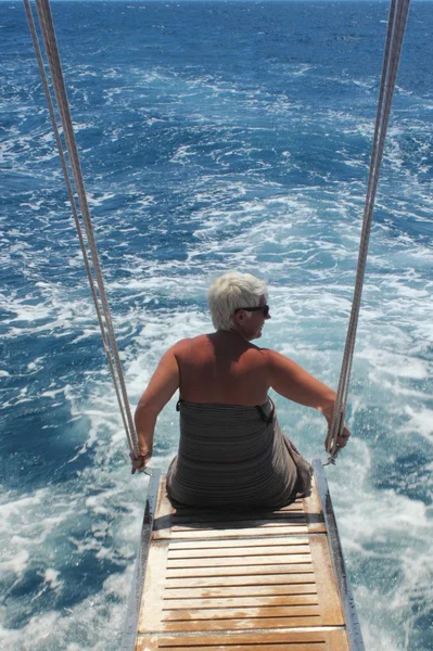 Женщина, сидящая на заднем сиденье моторной лодки — стоковое фото