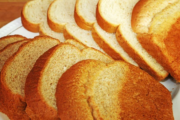 Plaka üzerinde buğday ve beyaz ekmek dilimleri — Stok fotoğraf