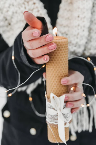 Kadın elinde bir mum tutuyor..