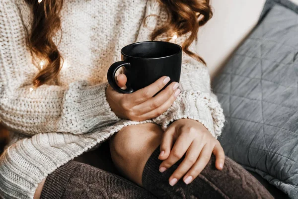 Bir kadının ellerinin fincan tutarken yakın plan fotoğrafı..