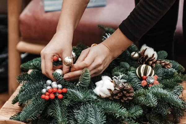 Kadın el yapımı Noel çelengini süslüyor..