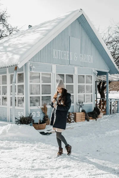 Kadın kış boyunca evin yanında duruyor..