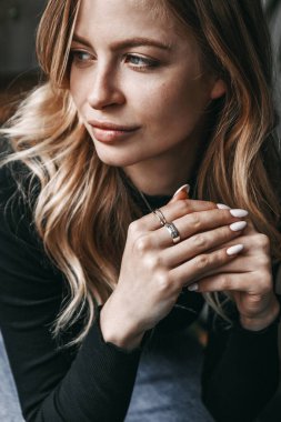 A close up portrait of a young female. She is thinking about som