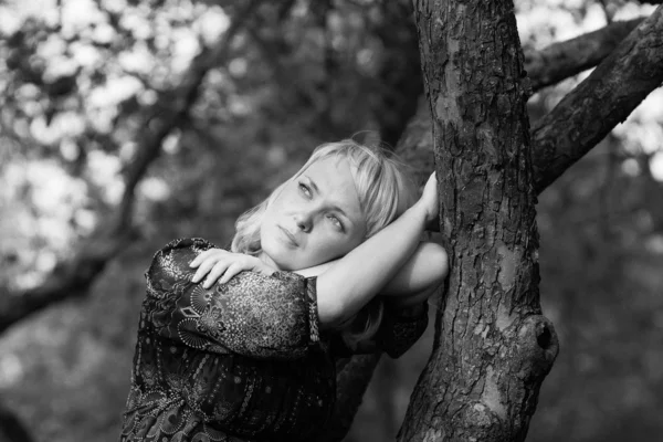 Smutek dívka sedící na větvi stromu — Stock fotografie