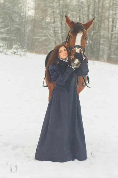 Hermosa mujer y caballo en invierno — Foto de Stock