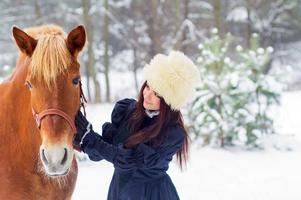 Vacker kvinna och häst i vinter — Stockfoto