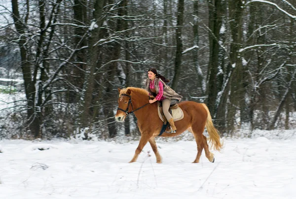 Mujer montando un caballo la nieve — Foto de Stock