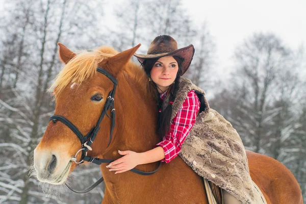 Frau reitet mit Pferd durch den Schnee — Stockfoto