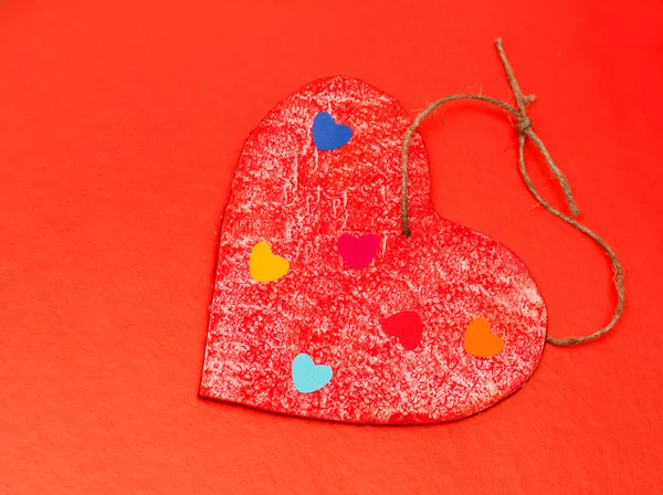 Πολύχρωμα χαρτί εστίες σε μια ξύλινη κόκκινη καρδιά — Φωτογραφία Αρχείου