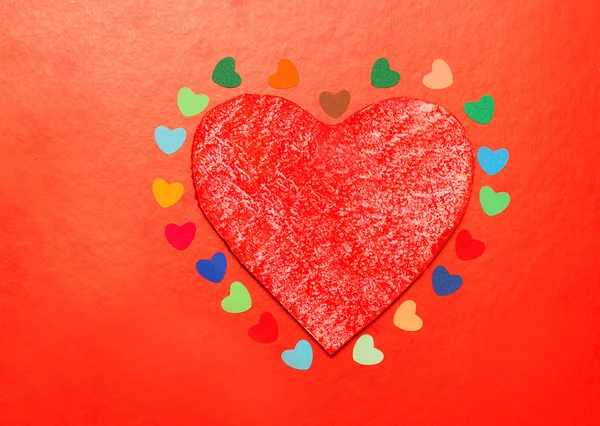 Çok renkli kağıt ocaklar çevresinde ahşap bir kırmızı kalp — Stok fotoğraf