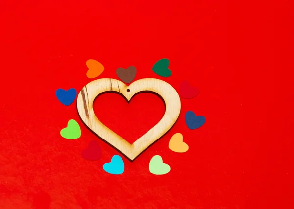 Hogares de papel multicolor alrededor de un corazón de madera — Foto de Stock