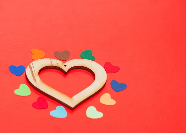 Hogares de papel multicolor alrededor de un corazón de madera — Foto de Stock