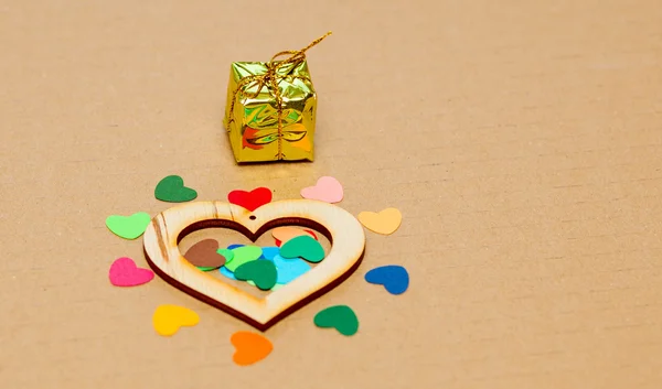 Wielobarwny papieru paleniska z drewnianym sercem i mały prezent — Zdjęcie stockowe
