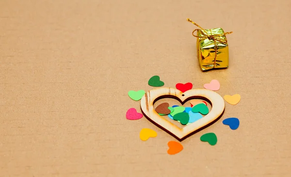 Hogares de papel multicolor con un corazón de madera y un pequeño regalo — Foto de Stock