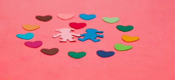 Multicolored paper hearths around multicolored paper boy and girl with hearth — Stock Photo, Image