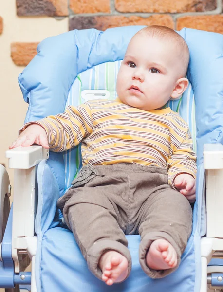 A baby sitting on high chair — Stock Photo, Image