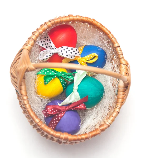 Разноцветные пасхальные яйца на плетеной корзине — стоковое фото