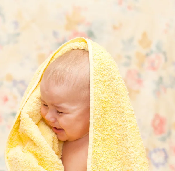 Bambino che piange in un asciugamano giallo — Foto Stock