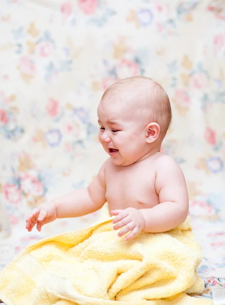 Baby crying in a yellow towel — Stock Photo, Image