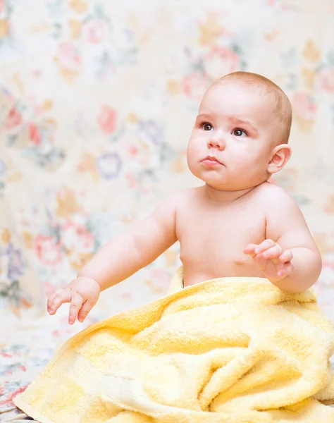 Baby weint in einem gelben Handtuch — Stockfoto