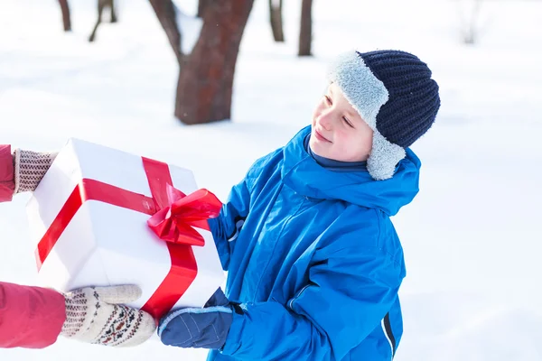 Femme donne un cadeau de Noël garçon — Photo