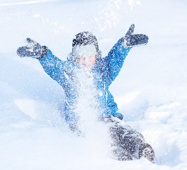 Szczęśliwy chłopiec bawi się ze śniegu — Zdjęcie stockowe