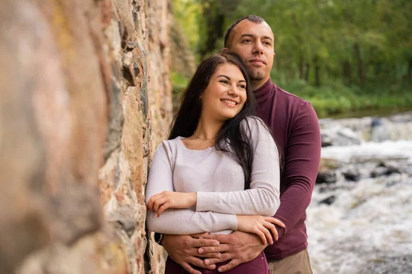 Beautiful young couple posing near the river — стоковое фото