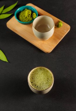 Matcha, taze çay yapraklarından pudra. Yaprak çayının aksine, matcha kaynar suyla doldurulmaz ve filtrelenmez, suda çözünür. Köpüklü bir kasede kibrit