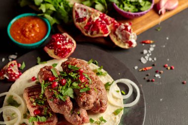 Lyulya-kebap, chevapchichi, kıymalı pirzola. Pide ekmeği, otlar, soğanlar ve sıcak domates sosuyla servis edilir. Yakın çekim, seçici odaklanma