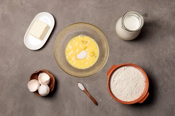 Amasar la masa en un bol. Batir los huevos con azúcar en un bol y los ingredientes para hacer masa. — Foto de Stock