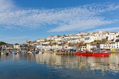 brixham harbour Devon evleri hillside ve kırmızı renkli tekneler ile sakin bir hala yaz yaz günü mavi gökyüzü, geleneksel İngiliz sahil sahne ile demirlemiş..