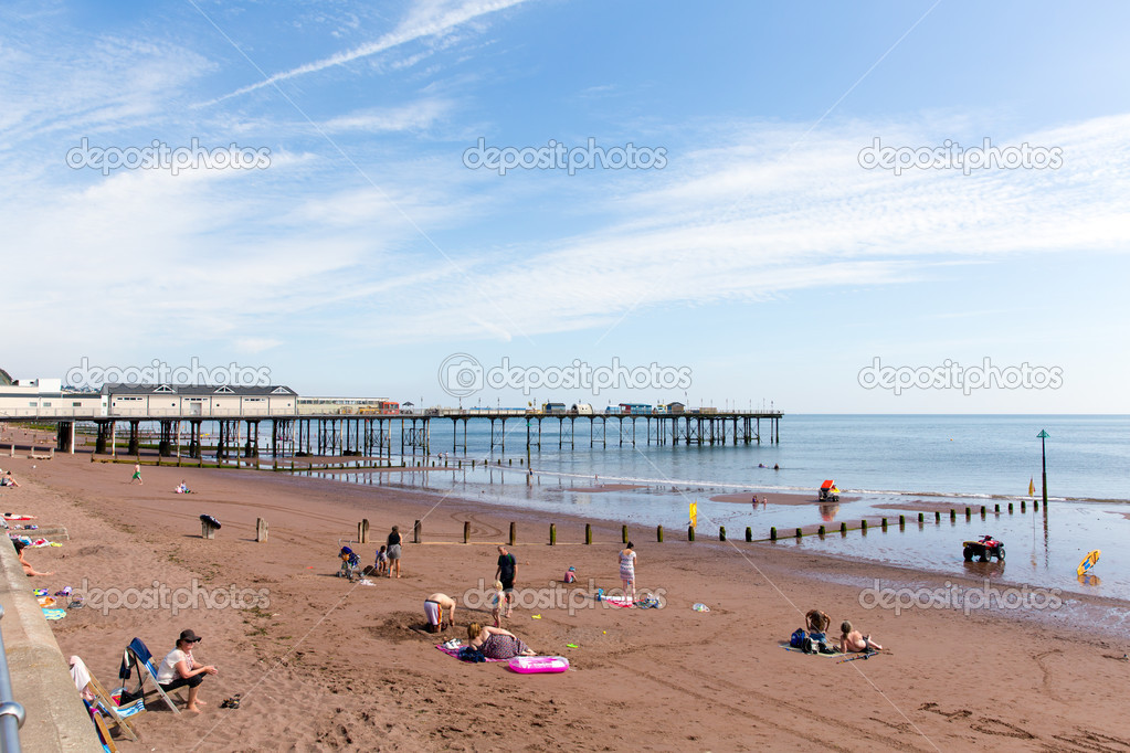 Tourists on Teignmouth beach Devon England enjoying the sunny warm