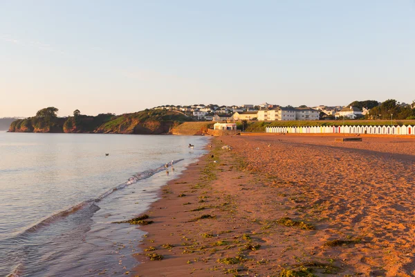 Goodrington playa cerca de Paignton Devon Inglaterra con coloridas cabañas de playa en una mañana de verano —  Fotos de Stock