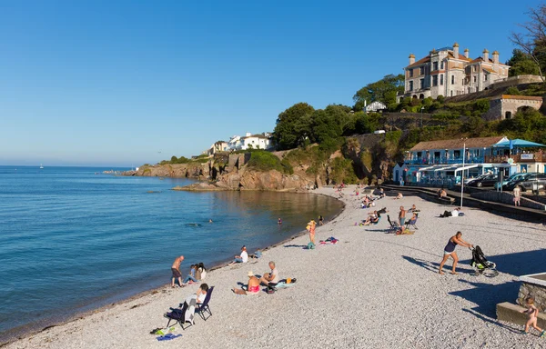 Vakantiegangers op brixham golfbreker strand devon Engeland Verenigd Koninkrijk in de zomer met blauwe hemel — Stockfoto