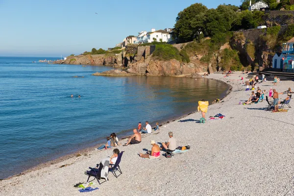 Turisták brixham hullámtörő strand devon Anglia Egyesült Királyság a nyári kék ég — Stock Fotó