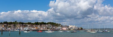 Cowes harbour Isle of Wight with blue sky and white clouds and boats clipart