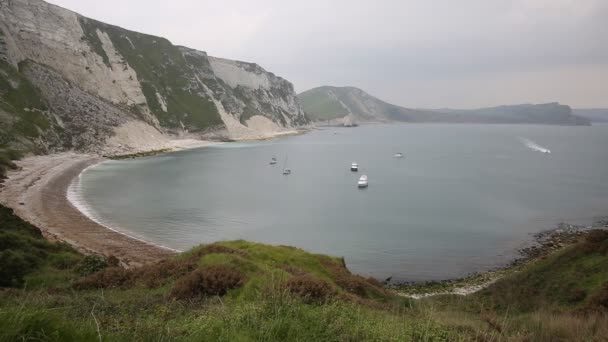 Boat entering Mupe Bay shingle beach east of Lulworth Cove Dorset England and is part of the Jurassic Coast World Heritage Site — Stock Video