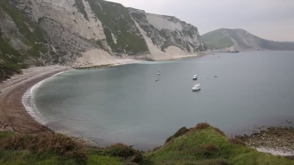 Barcos en Mupe Bay playa de guijarros al este de Lulworth Cove Dorset Inglaterra y es parte de la Costa Jurásica Patrimonio de la Humanidad — Vídeos de Stock