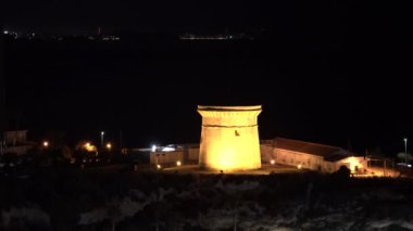 El Campello İspanya Kulesi. Costa Blanca turistik merkezi. Arka planda Benidorm 'un ışıkları parlıyordu.