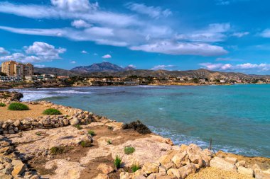 İspanya 'nın Alicante kenti El Campello' daki tarihi La Illeta turistik beldesine 6 Nisan 2022 Çarşamba günü ziyaretçiler tarafından gün ışığı ve mavi gökyüzünün keyfini çıkardılar.